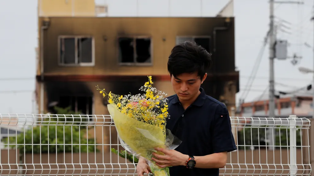 Muž přinesl kytici k uctění obětí požáru studia animovaného filmu v Kjótu