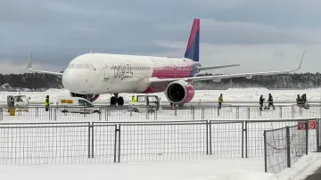 Sněhem pokryté letadlo stojící na odbavovací ploše letiště Modlin poblíž Varšavy, 31. prosince 2025