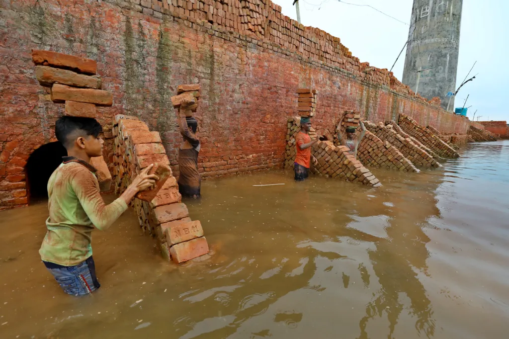Cihláři z bangladéšského Savaru zachraňují během záplav nevypálené cihly, které by se ve vodě rychle rozpadly
