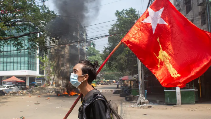 Myanmarský demonstrant drží vlajku Národní ligy pro demokracii