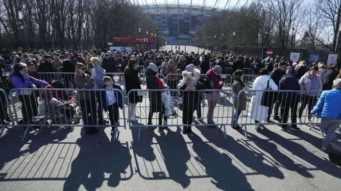 Ukrajinští uprchlíci čekají na registraci před Národním stadionem ve Varšavě