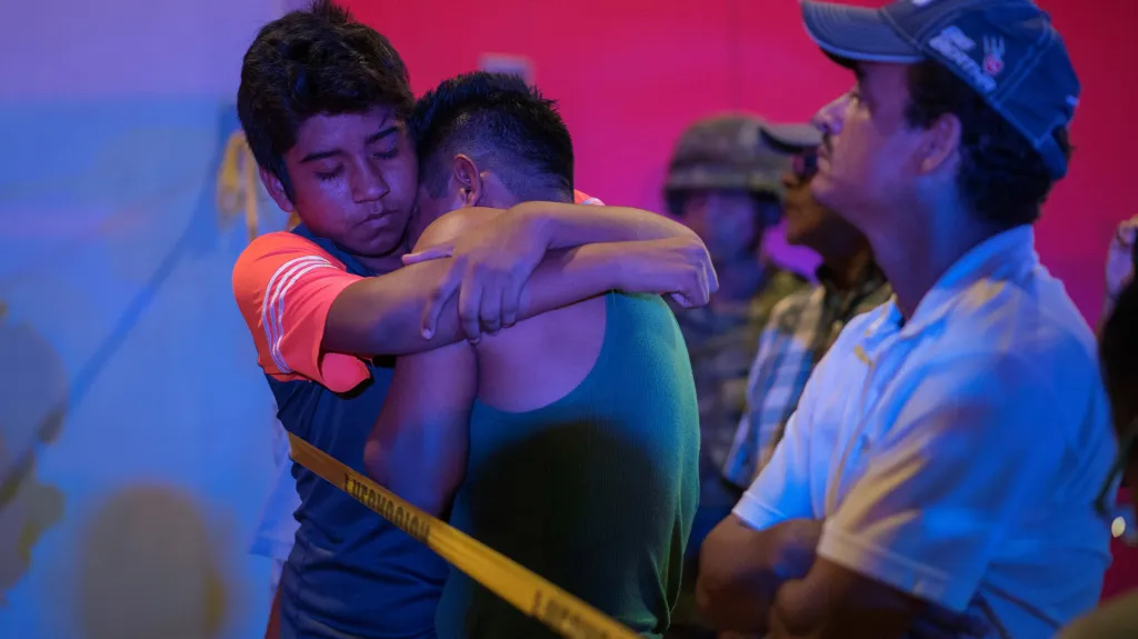 Mladí Mexičané se utěšují před vyhořelým barem