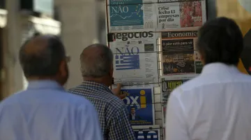 Portugalci si čtou titulní strany novin, které informují o výsledku řeckého referenda