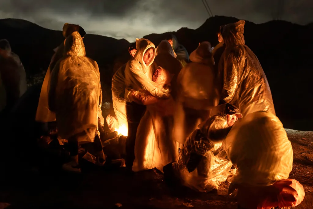 Finalista World Press Photo 2025 – Noční přechod (Night Crossing) – Čínští migranti překročili hranici s Mexikem v kalifornském Campu a snaží se v dešti zahřát