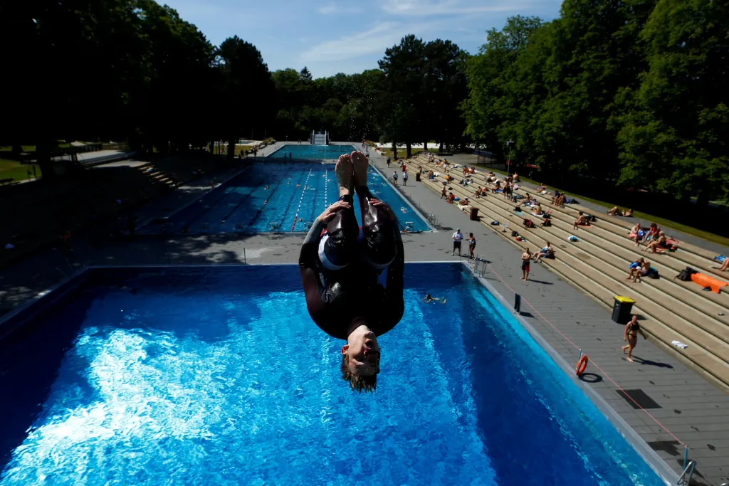 V Německu se dál uvolňují opatření proti šíření pandemie. Mladý muž skáče do znovuotevřeného bazénu v Kolíně nad Rýnem