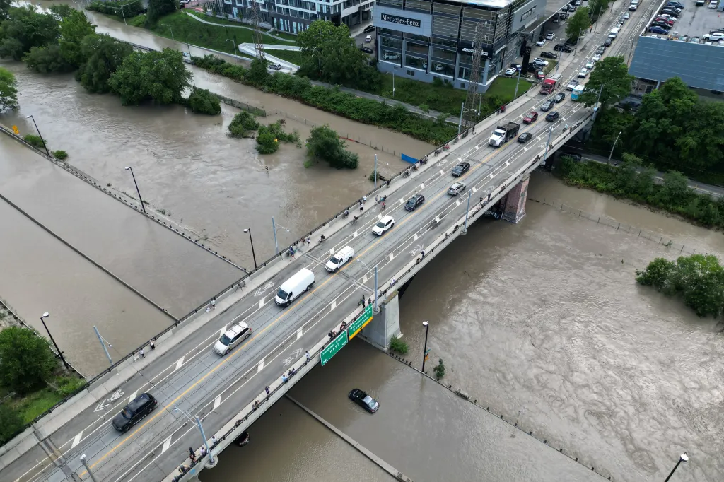 Vozidla přejíždějí přes most přes zaplavený úsek Don Valley Parkway