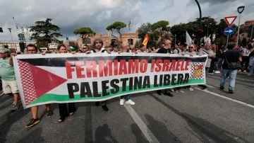 Demonstranti v Římě drží transparent s nápisem „Zastavme Izrael, osvoboďme Palestinu“ během celostátní stávky s heslem „Zablokujme všechno“ na podporu Gazy a s výzvou k zastavení dodávek zbraní do Izraele (22. září 2025)