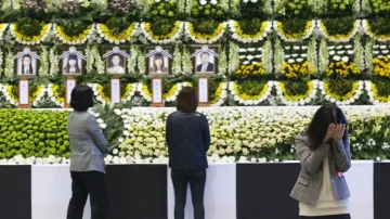 Lidé truchlí u fotografií obětí jihokorejské tragédie