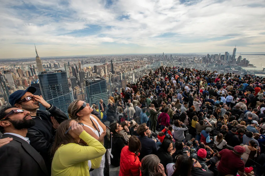 Lidé sledují zatmění Slunce na vyhlídkové plošině Edge v New Yorku
