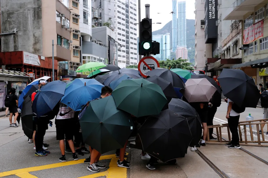 Protivládní protesty v Hongkongu opět zesilují. Na snímku skupina demonstranů skrývá svou identitu a domlouvá plán protestů