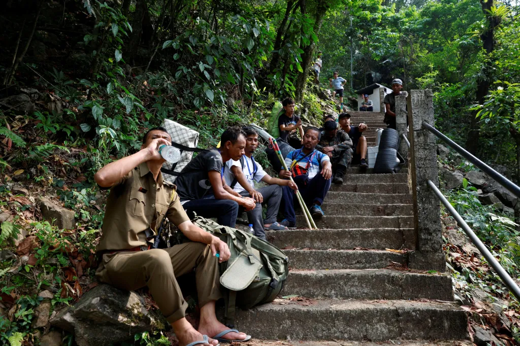 Volební komisaři a nosiči odpočívají na cestě do vesnice v blízkosti města Šillong