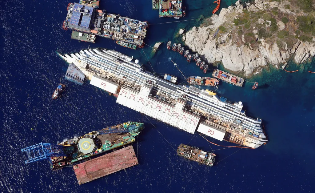 Letecký pohled ukazuje výletní loď Costa Concordia ležící na boku u ostrova Giglio v Itálii poté, co se vinou posádky převrátila. Snímek pořízený 26. srpna 2013