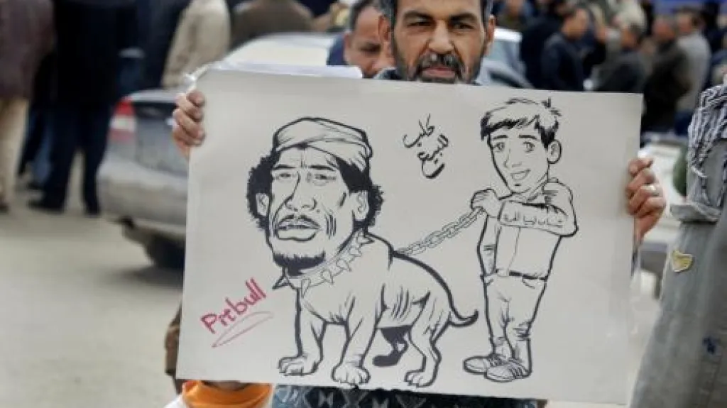 Protestující Libyjec s karitkaturou Muammara Kaddáfího