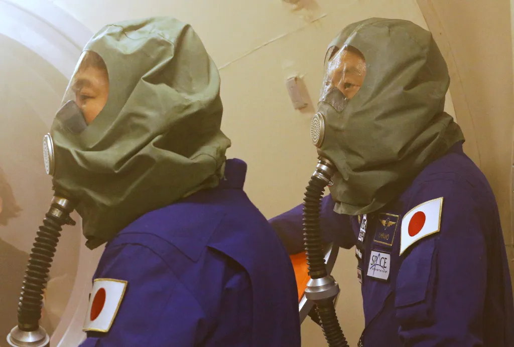 Účastníci vesmírného letu Júsaku Maezawa a Yozo Hirano se zúčastnili školení před expedicí na Mezinárodní vesmírnou stanici ve Star City v Rusku. Na snímku mají astronauti na sobě obličejové masky, které se využívají během požáru na palubě ISS