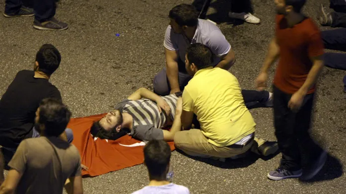 Lidé v ulicích Ankary ošetřují zraněného muže