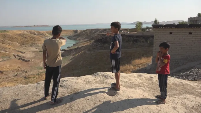 Irácké děti ukazují na přehradu u Mosulu