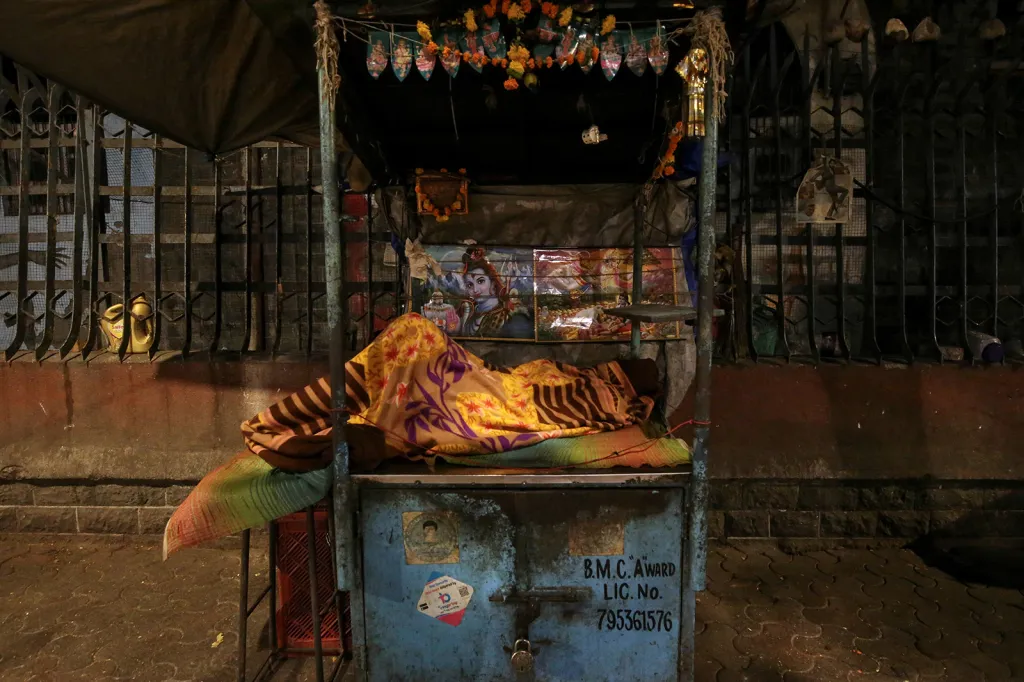 Spící muž na ulici v ranních hodinách v centru indické Bombaje