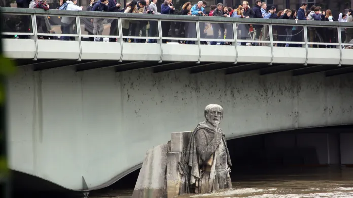 Lidé pozorují rozvodněnou Seinu z mostu Alma v Paříži