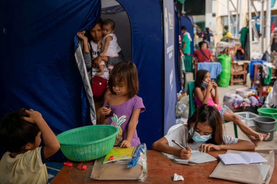 Nicole Cabasines (11 let) pracuje na svém domácím cvičení v evakuačním táboře u vesnice Kasiglahan. Zemi ke konci uplynulého roku zasáhl silný tajfun, jehož následky se budou odstraňovat několik let. Tisíce obyvatel jsou stále bez přístřeší. Což je další komplikace, která obyvatelům hlavního města v době pandemie situaci vůbec neulehčuje