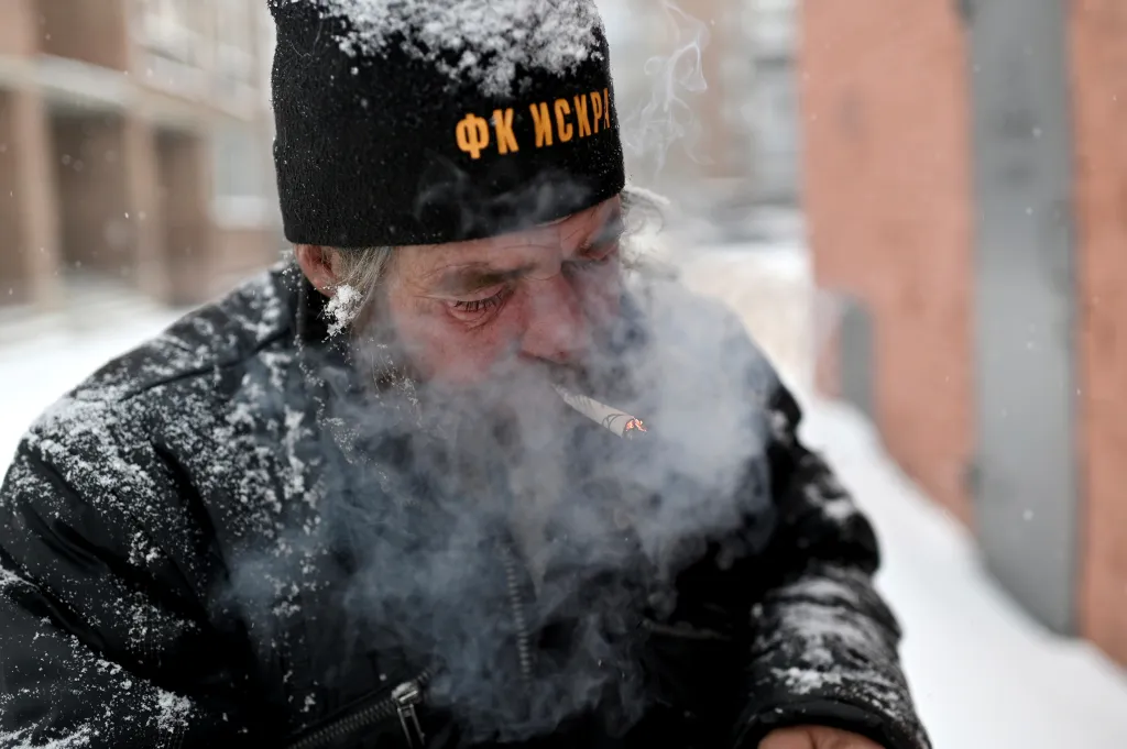 Bezdomovec Alexej Vergunov kouří cigaretu, kterou si vyrobil z kousku papíru
