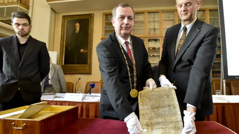 Rektor Tomáš Zima a ředitel Ústavu dějin Univerzity Karlovy Petr Svobodný s historickými dokumenty