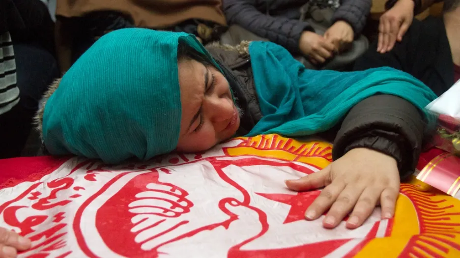 Žena pláče nad rakví Šukrího Bilajda
