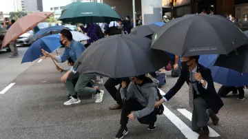 Lidé se kryjí deštníky