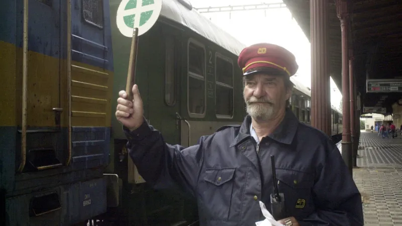 Snímek v léta 2003: I když již půl roku existuje SŽDC, výpravčí je zaměstnancem Českých drah a nádraží v Přerově také patří Českým drahám. Se Správou železniční dopravní cesty přesto fotka souvisí – vznikla u příležitosti dokončení modernizace II. tranzitního železničního koridoru. Rekonstrukce tratí byly zprvu tím hlavním, co měla SŽDC na starost.