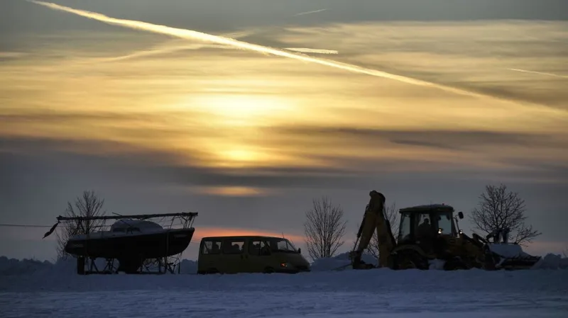 Dodávka s lodí na návěsu jede po zasněžené vysočinské silnici v závěsu za sypačem – jinak to nejde.