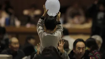 Chlapec si hraje s nafukovacím balonem v evakuačním centru provizorně vytvořeném v gymnáziu Kawamata