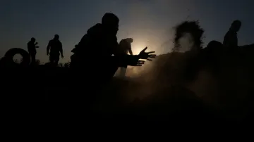 Palestinský demonstrant ve snaze uhasit oheň, který vznikl na palestinském území z objektů vyhozených z izraelských dronů během protestů proti přemisťování americké ambasády do Jeruzaléma