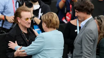 Bono ze skupiny U2 se vítá s bývalou německou kancléřkou Angelou Merkelovou a bývalým kanadským premiérem Justinem Trudeau