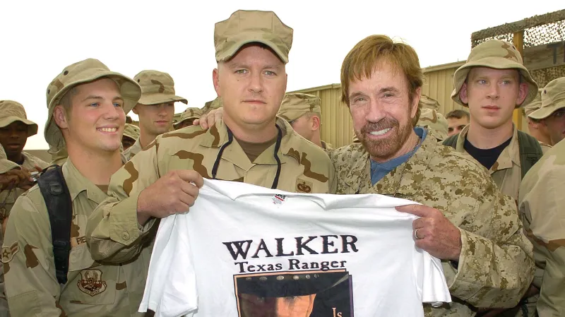 Chuck Norris na americké základně v Kuvajtu (2006), od vojáků dostal tričko s fotkou ze seriálu Walker Texas Ranger