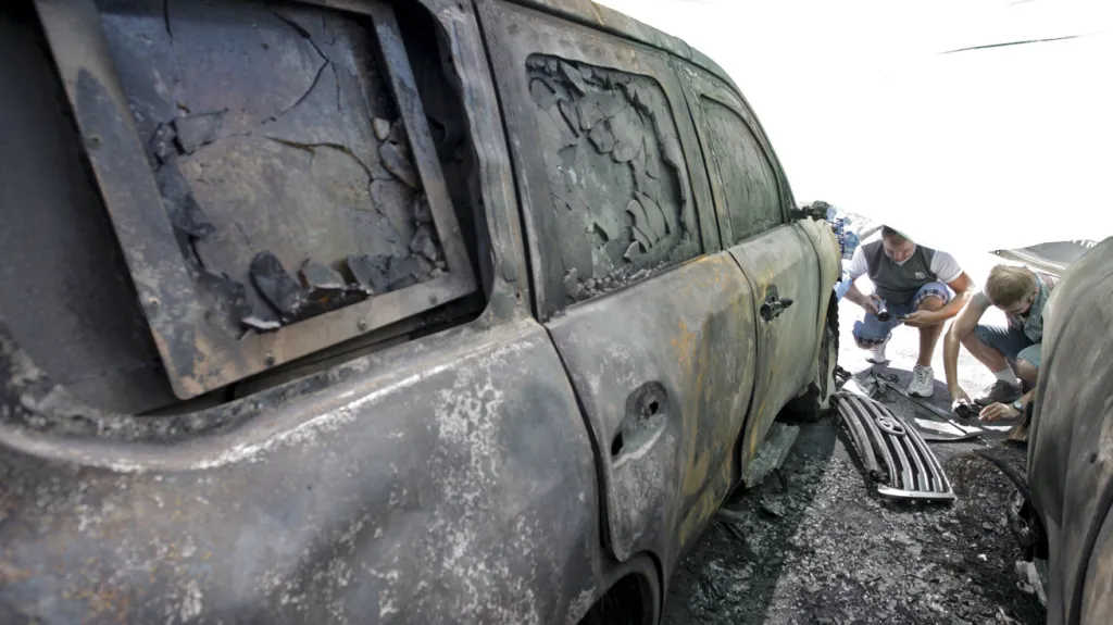 Následky žhářského útoku na vozidla OBSE na Ukrajině