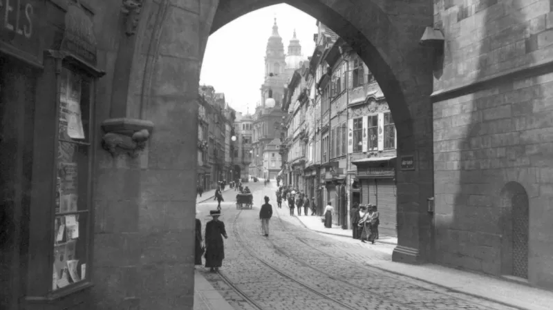 Tramvajové koleje na snímku datovaném přibližně k roku 1909 jsou již nevyužívané. Po Karlově mostě a Mosteckou ulicí po zavedení elektřiny jezdila nejprve běžná tramvajová linka, později zvláštní kyvadlová linka, ale v roce 1908 ji nahradily autobusy. Jejich provoz byl zastaven na podzim 1909, ale tramvaje se již nevrátily.