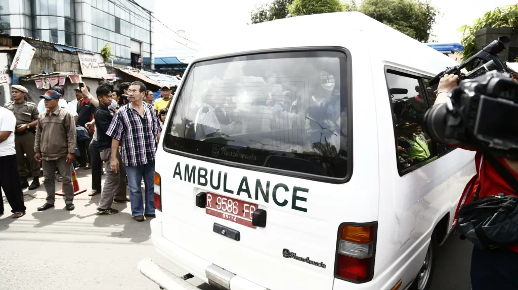 Ambulance převáží rakev jednoho z popravených