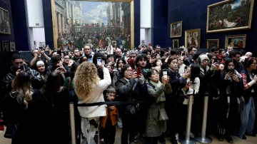 Turisté v Louvru fotografují obraz Mona Lisa od Leonarda da Vinciho