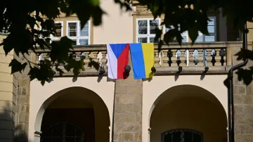 Česká a ukrajinská vlajka na budově Poslanecké sněmovny