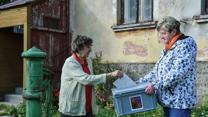 Jedna z voliček v Kořenově na Jablonecku odevzdává hlas do přenosné urny