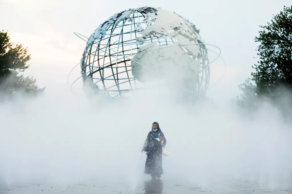 Nadměrné teploty v USA nutí lidi využívat jakéhokoliv prostředku, který by je ochladil. Na snímku prochází muslimská žena se zmrzlinou umělou mlhou v parku Flushing Meadows-Corona, který se nachází v části Queensu v New Yorku