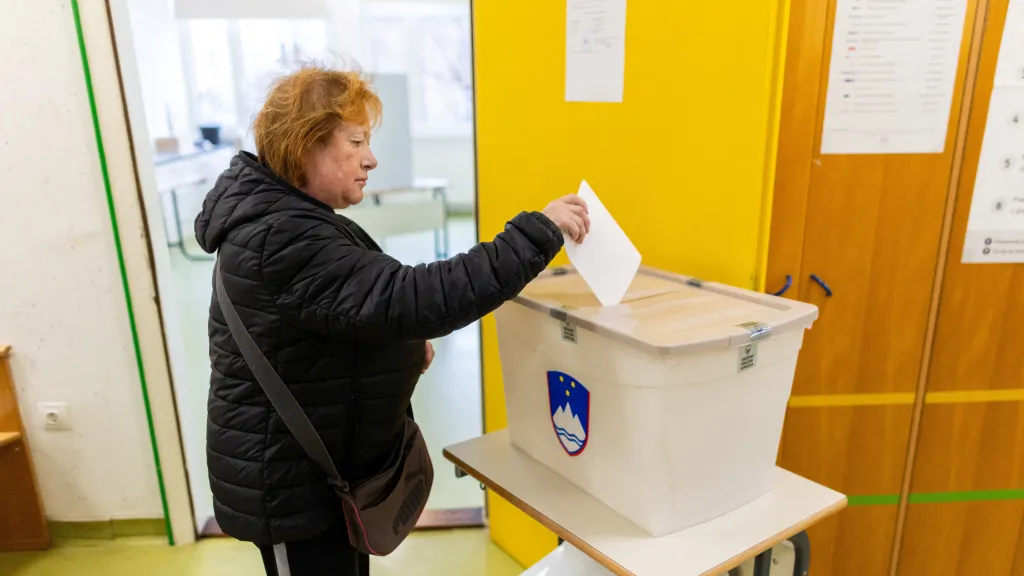 Žena odevzdává svůj hlas ve volební místnosti ve Slovinsku