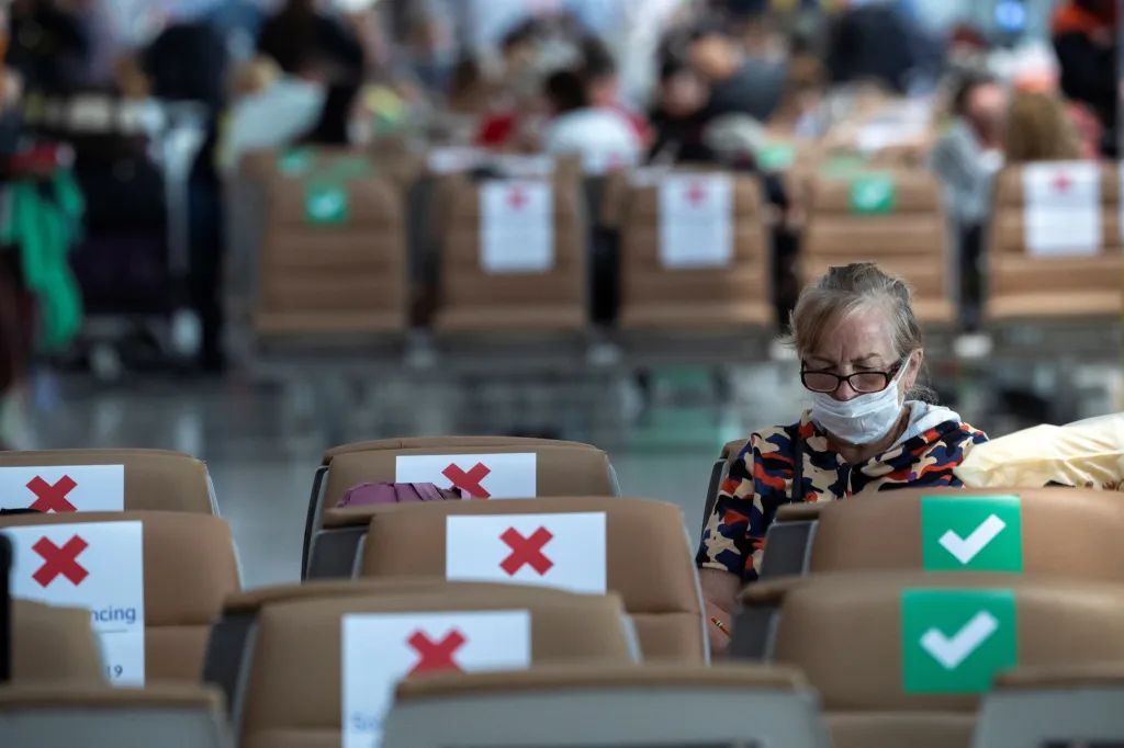 Pasážeři čekají na odbavení na letišti v Bangkoku. Křížkem označená místa nesmí nikdo obsadit