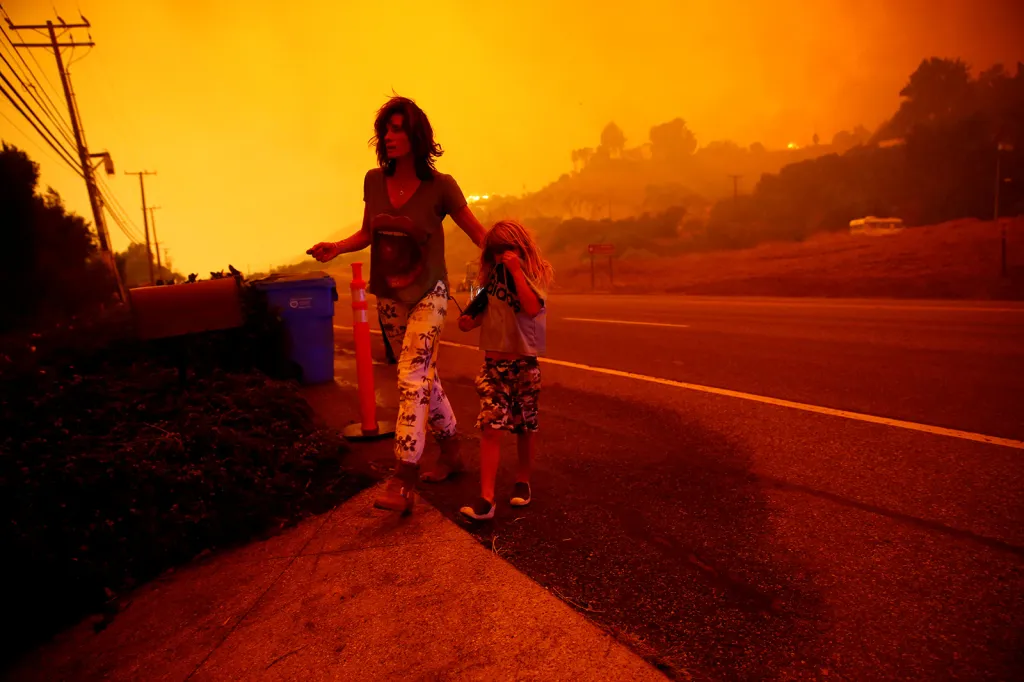 Matka s dcerou na krajnici Pacific Coast Highway. V pozadí požár Woolsey spaluje jejich obydlí v kalifornském Malibu. Požáry donutily tisíce lidí k evakuaci, některá města zcela lehla popelem