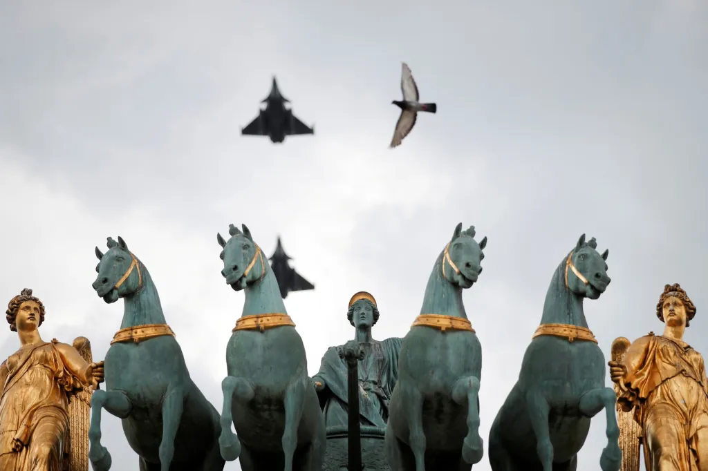 Francouzské stíhací letouny Dassault Rafale letí nad sochami Arc de Triomphe du Carrousel během zkoušky vojenské přehlídky k výročí pádu Bastily v Paříži