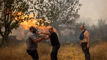 Dobrovolníci poblíž Atén se snaží uhasit plameny. Foceno 22. srpna 2023